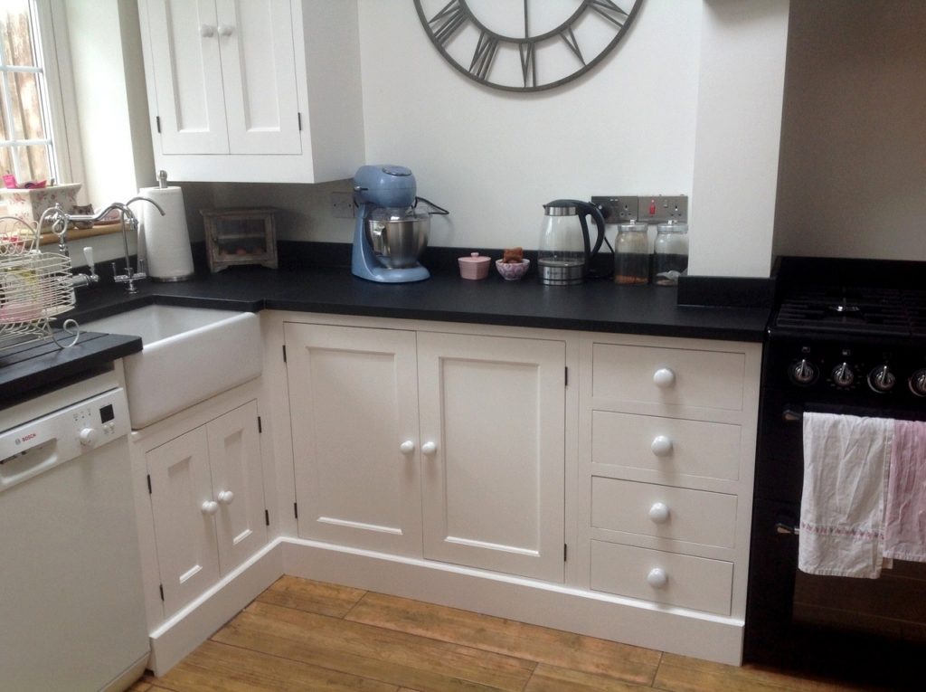 a painted solid wood kitchen painted white with a belfast sink